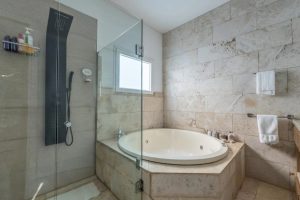 Baño suite con tina y ducha de vidrio, Casa Orillas Lago Rapel