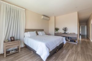 Dormitorio con cama doble y ventana al jardín, Casa Orillas Lago Rapel