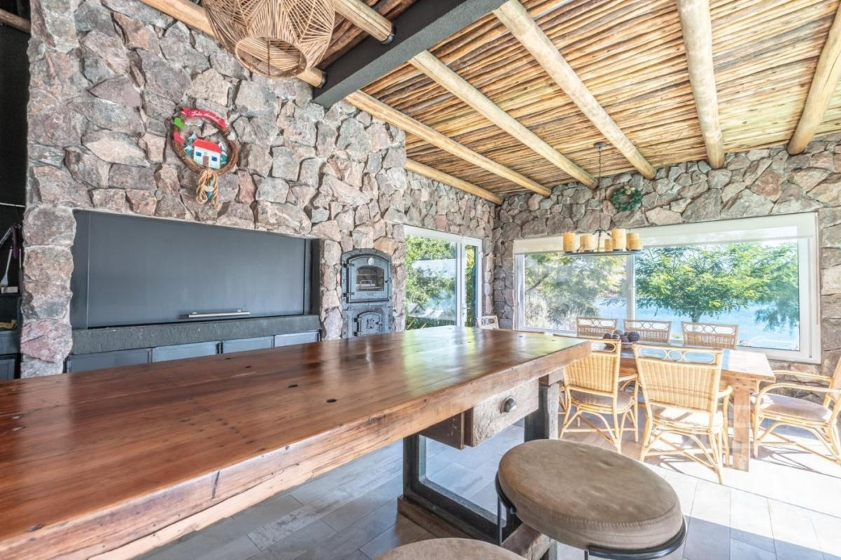 Terraza de piedra con mesa y sillas frente al lago