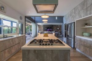 Cocina con isla central y comedor integrado, Casa Orillas Lago Rapel