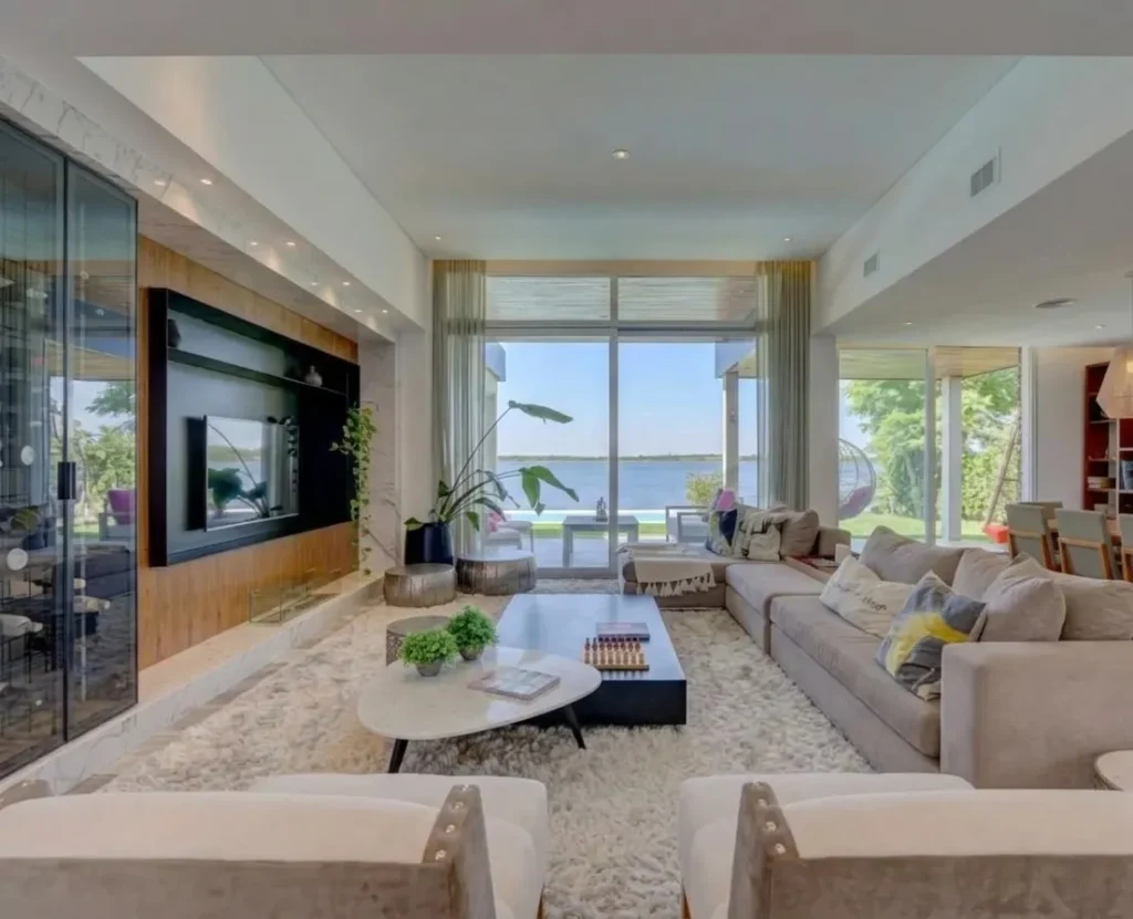 Living con ventanales de piso a cielo y vista al lago